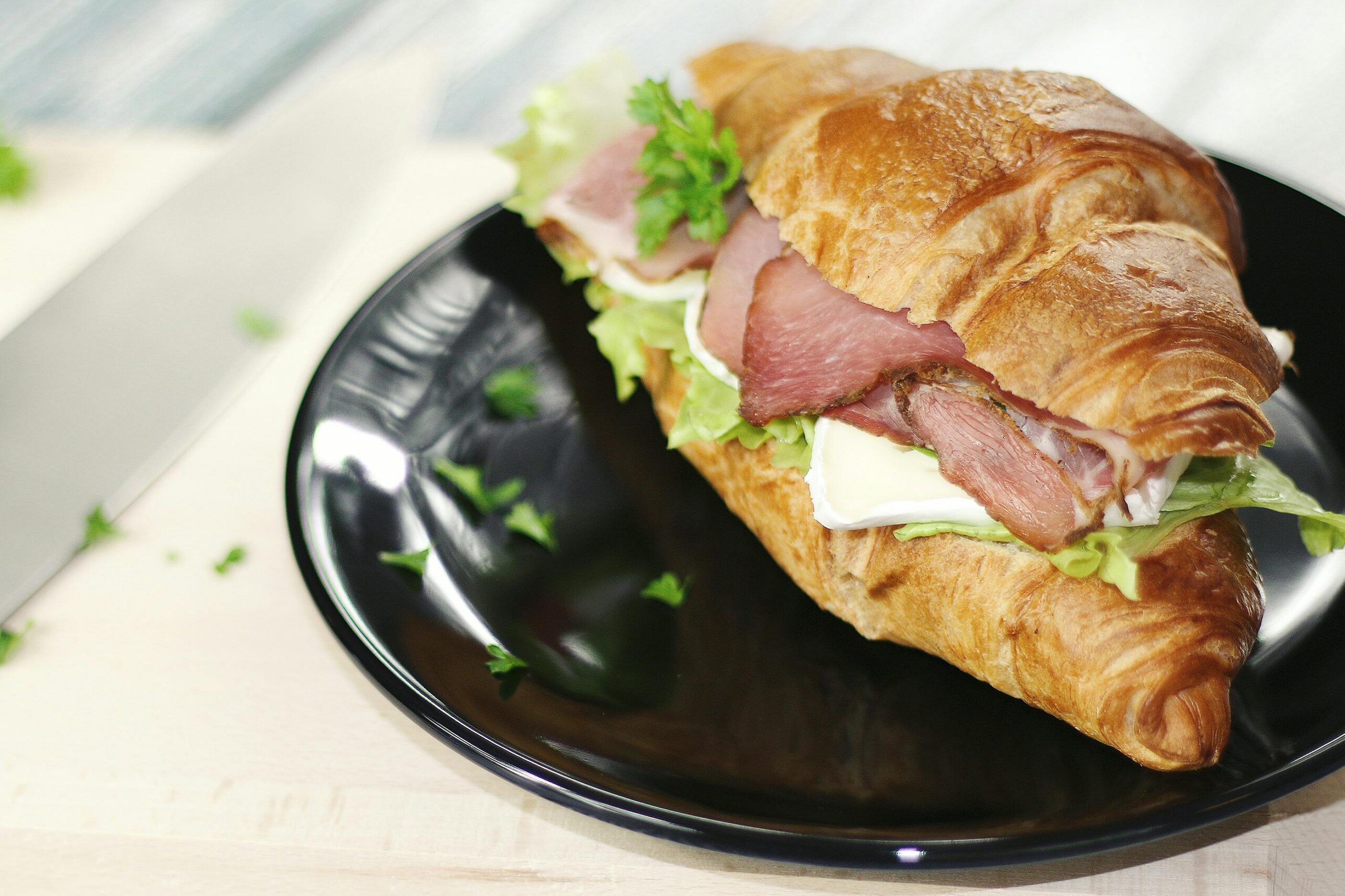 Plate of Croissant Sandwich with Ham, Lettuce & Cheese