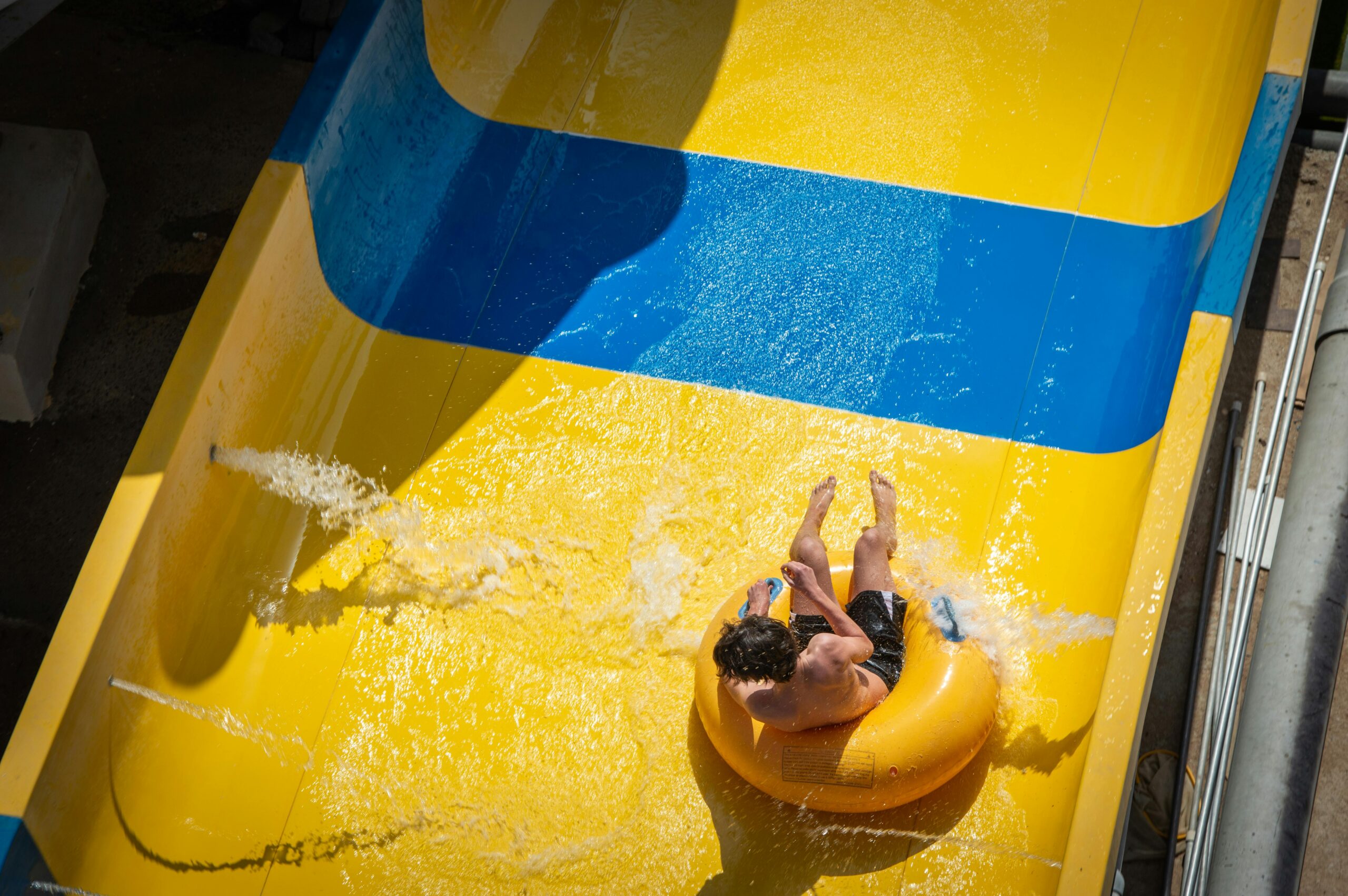 A visitor splashing down a large water slide on an inner tube, perfect for a summer day at a Branson water park.