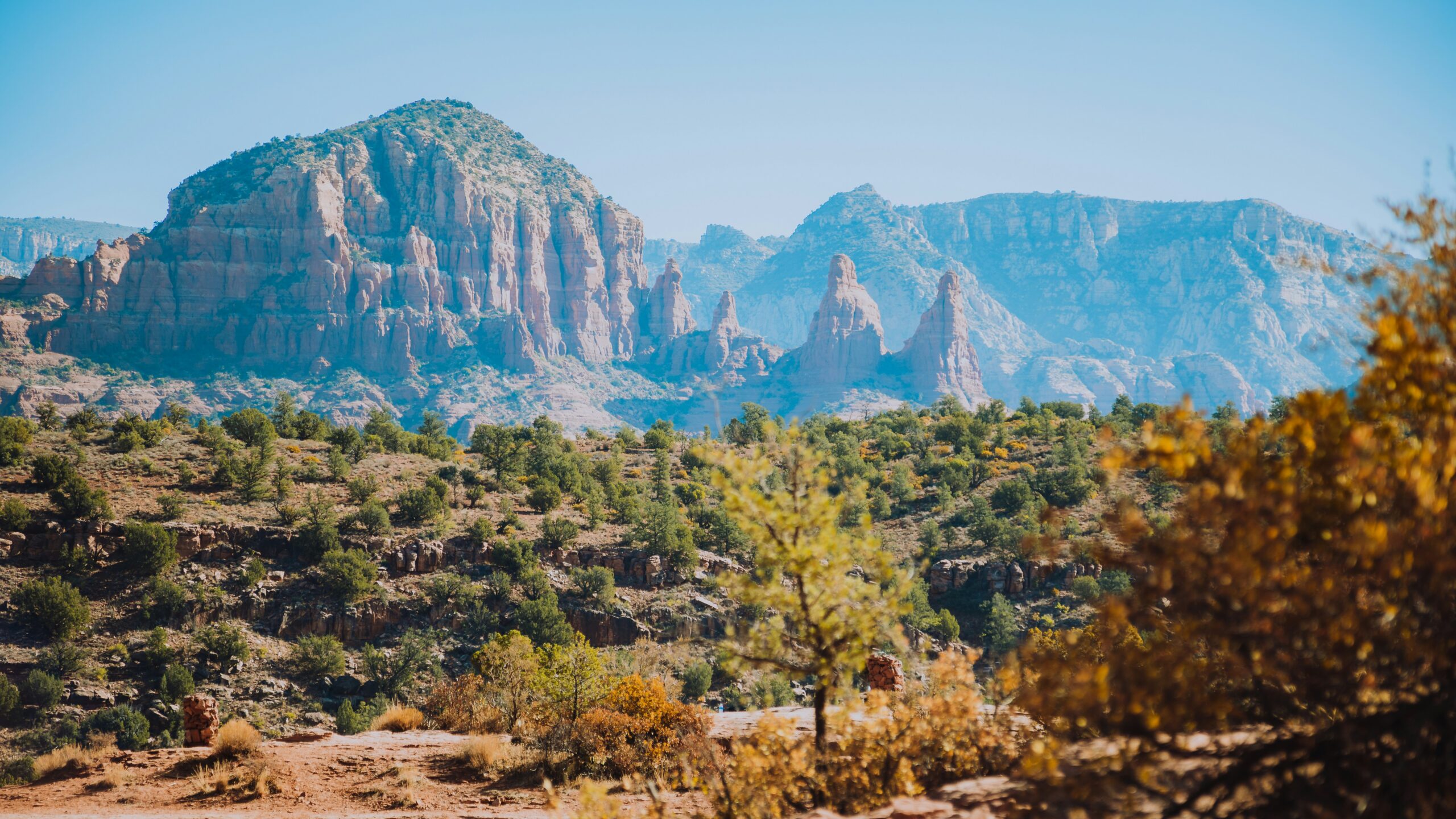 Red rock mountain views surrounded by fall foilage trees.