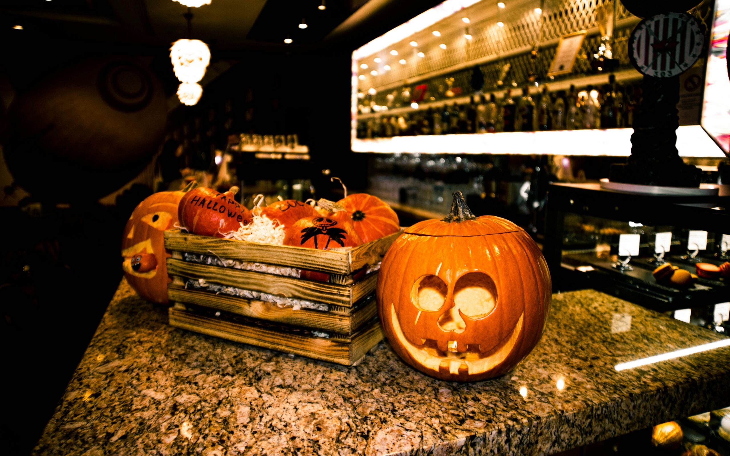 Carved jack-o'-lanterns and festive Halloween pumpkin decorations on a bar counter in Savannah