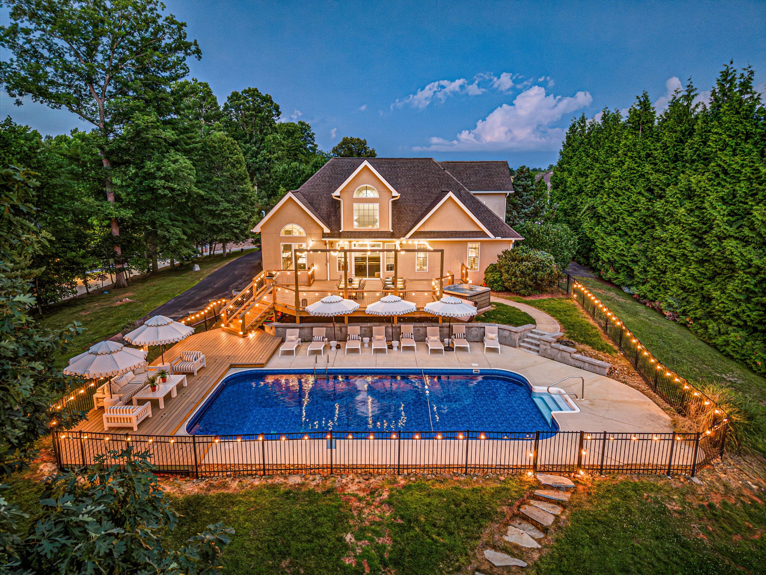 Aerial photo of a Mighty Tree Properties Asheville vacation rental backyard illuminated by string lights.