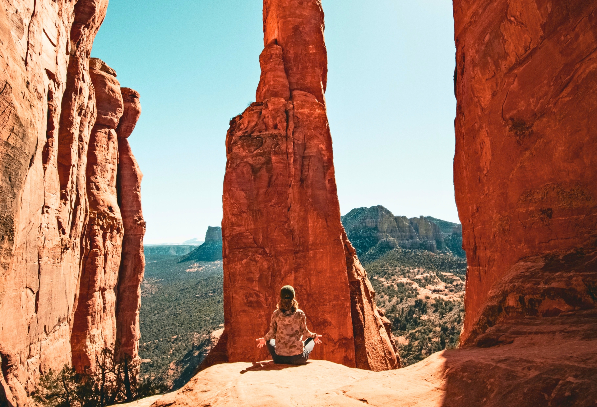 Woman meditating atop the Cathedral Rock after a successful hike.